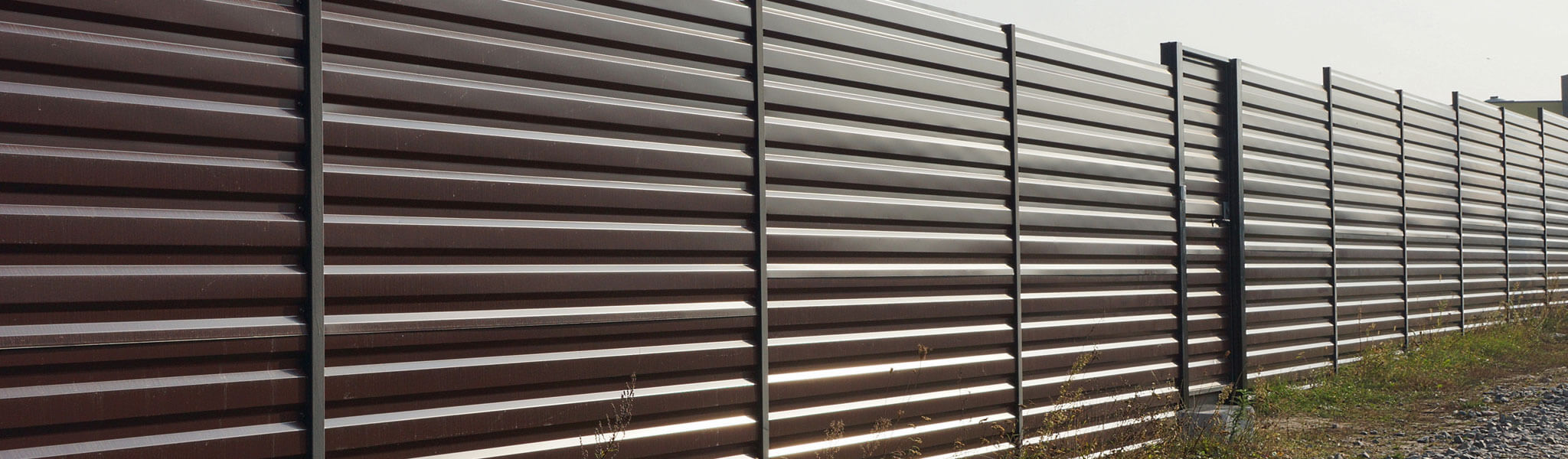 Private Brown Metal Fence Outside In Grass